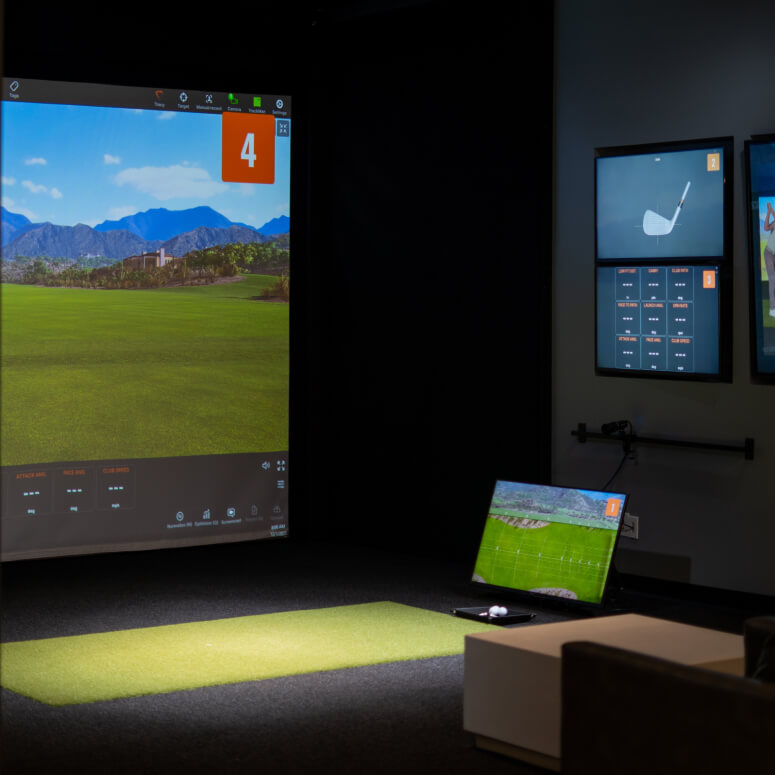 Golf instructor demonstrating swing analysis with TrackMan data during a lesson at Studio Golf Clearwater.
