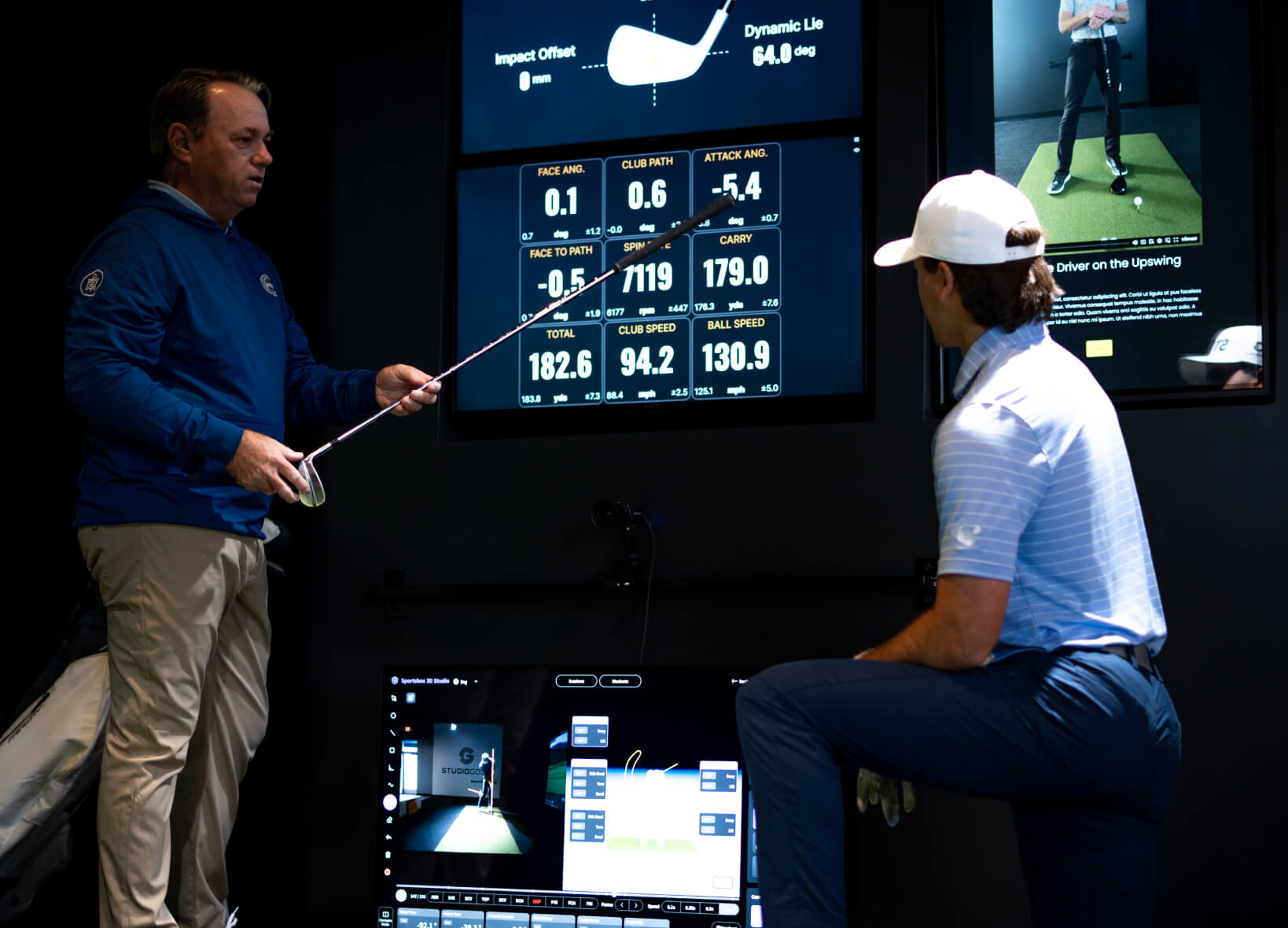 Golf coach conducting a detailed swing analysis with a player using TrackMan data and Sportsbox AI at Studio Golf.