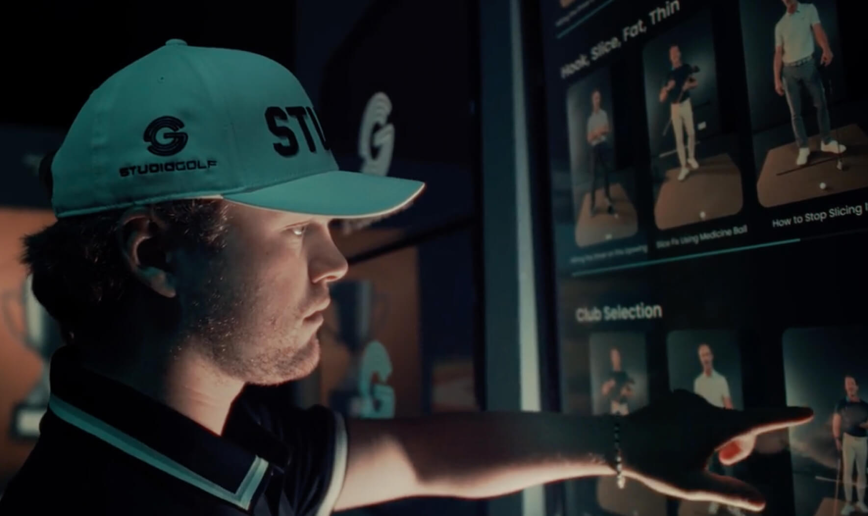 Golfer using Studio Golf’s interactive touchscreen system to access personalized swing drills.