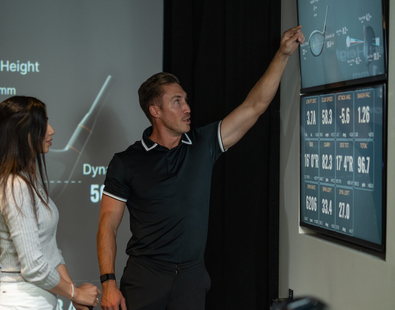 Golf instructor using TrackMan technology to analyze ball and club data with a student at Studio Golf.